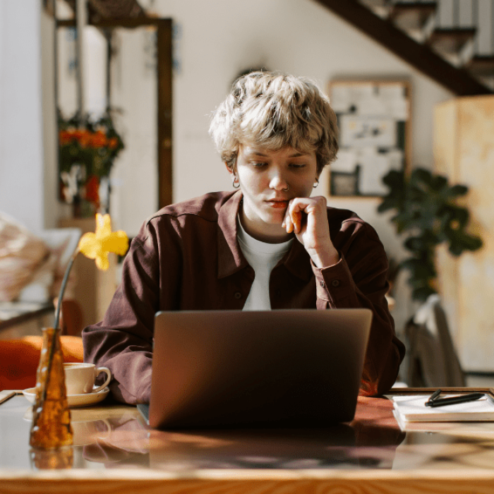 Adulto com TDAH concentrado estudando no notebook, aplicando atividades de concentração para TDAH